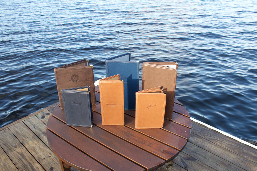 Menus Tendance en cuirette de plusieurs couleurs sur table au bord du lac